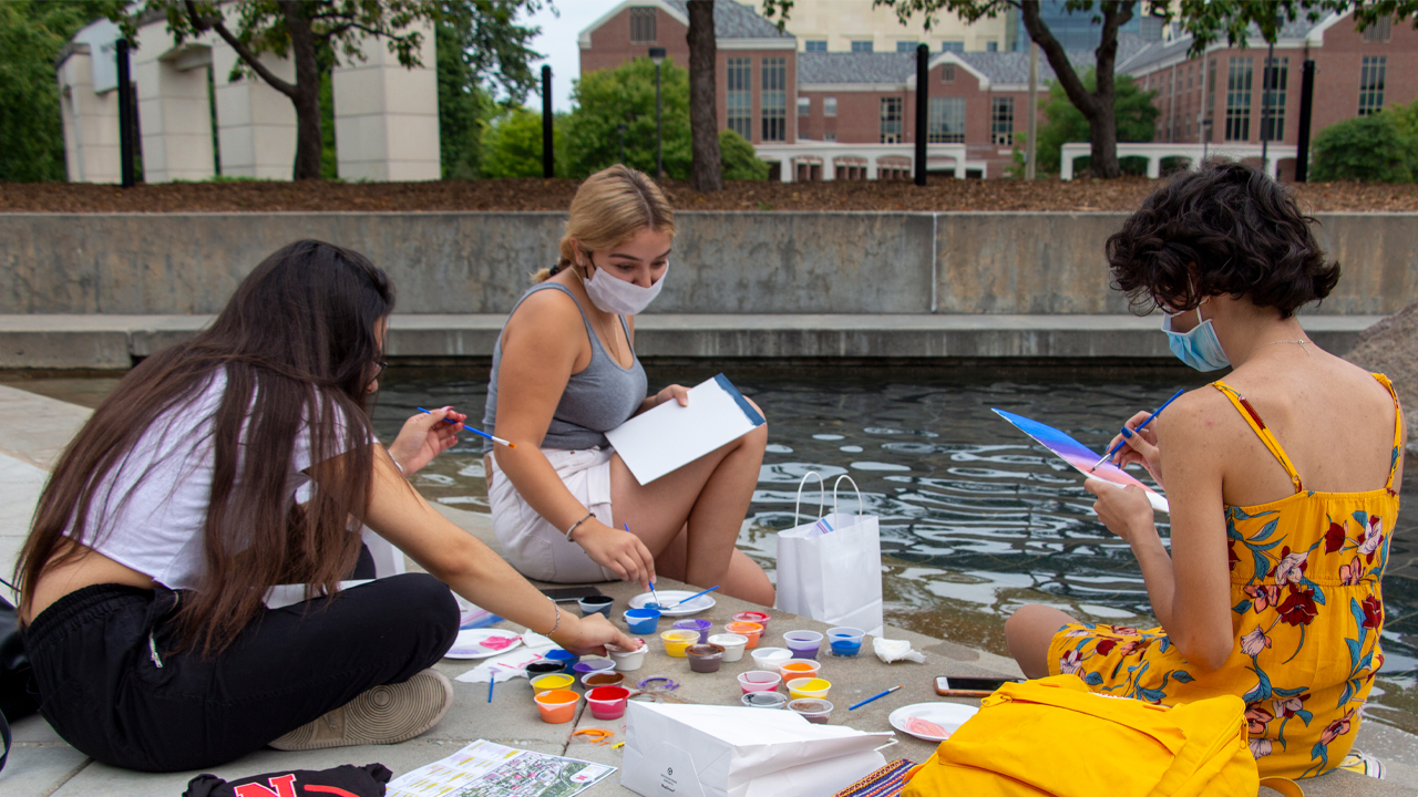 Students painting at a fountain